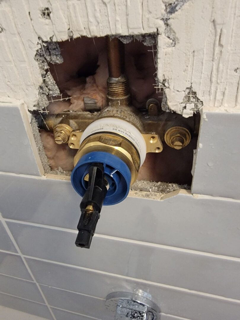 Shower valve cartridge replacement in a tiled bathroom