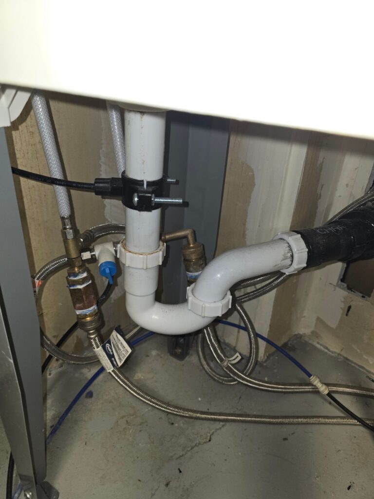Under-sink drain trap and water supply lines after a leak repair by DMS Plumbing